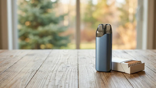 A blue vape pod device stands next to an open pack of cigarettes on a wooden table, representing vaping alternatives.