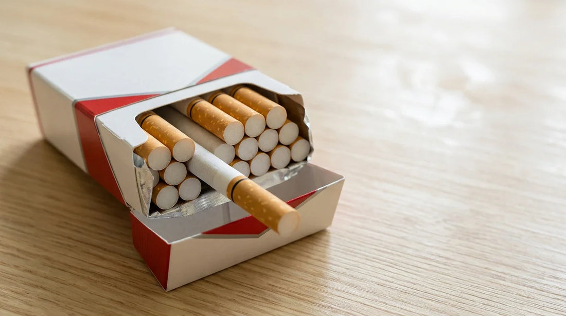 An open red and white cigarette pack on a wooden surface showing the quantity of cigarettes inside.