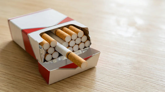 An open red and white cigarette pack on a wooden surface showing the quantity of cigarettes inside.