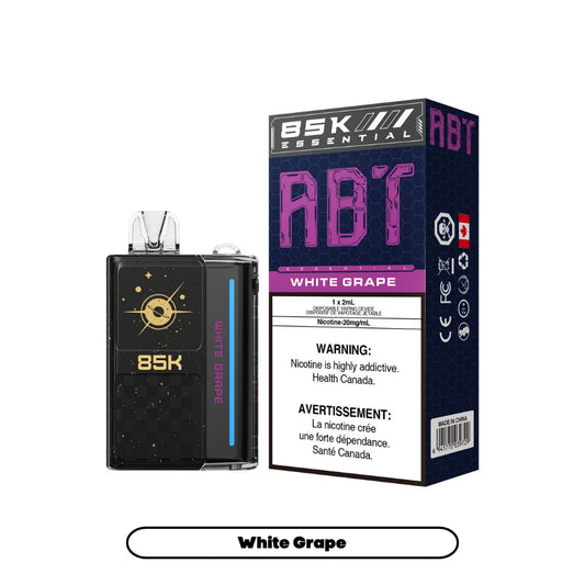 An ABT 85K disposable vape device in black with gold space-themed graphics sits next to its matching rectangular product box labeled White Grape, featuring a 20mg/mL nicotine warning and Health Canada branding against a dark blue honeycomb pattern.