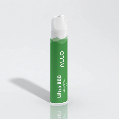 Allo Ultra 800 Melon Ice disposable vape featuring a green cylindrical body with a white mouthpiece, labeled with Allo Ultra 800 Melon Ice Melon Glacé text, shown on a reflective white surface.