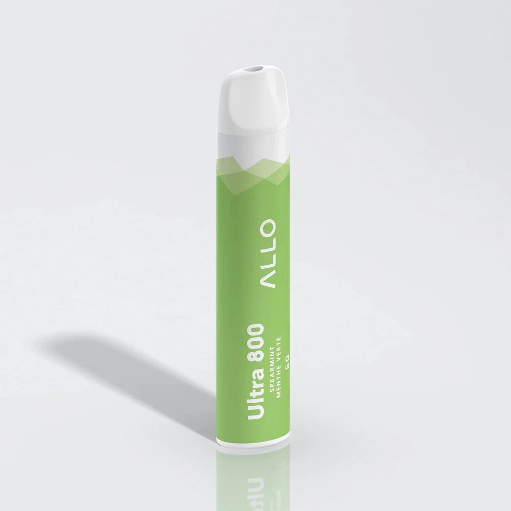 An ALLO Ultra 800 Spearmint disposable vape featuring a green and white cylindrical body with a white mouthpiece, labeled with ALLO and Ultra 800 Spearmint Menthe Verte text, standing upright on a reflective white surface.