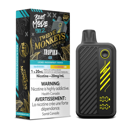 A Beast Mode Max 2 disposable vape device stands next to its black and teal packaging, which features the Twelve Monkeys Vapor Co. logo, the Tropika Iced flavor name, and a 20mg/mL nicotine warning label, while the device itself displays a digital screen showing battery and liquid levels.