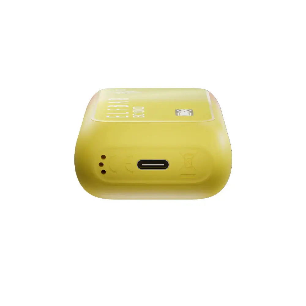 Bottom view of a yellow ELFBAR BC10000 Peach Mango disposable vape showing the USB-C charging port and air intake holes on a white background.