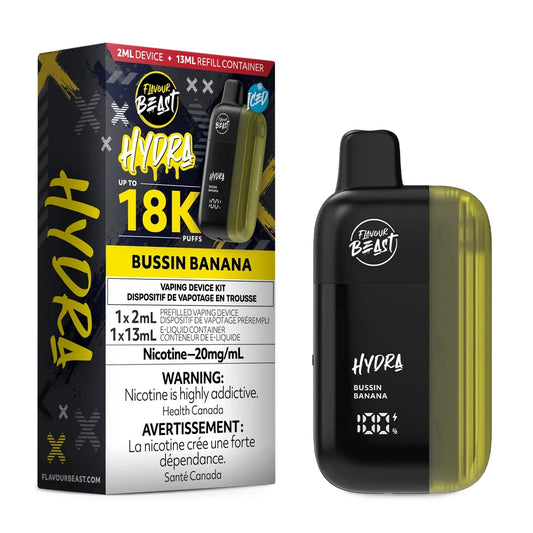 A Flavour Beast Hydra Bussin Banana disposable vape kit shown next to its black and yellow packaging, featuring a 2ml device, a 13ml refill container, and a digital display screen on a plain white background.