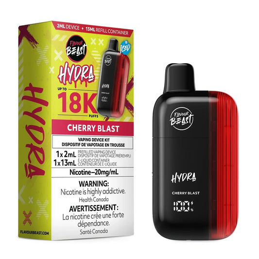 A Flavour Beast Hydra Cherry Blast disposable vape device stands next to its yellow and red product packaging, which displays the brand name, a 18K puff count, and a 20mg/mL nicotine warning label.