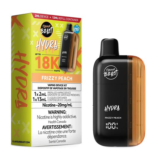 A Flavour Beast Hydra Frizzy Peach disposable vape device stands next to its yellow and orange retail box, which features the product name, a 18K puff count, and nicotine warning labels in English and French.