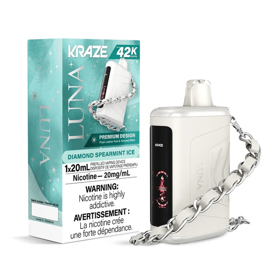 A white Kraze Luna Diamond Spearmint Ice disposable vape with a leather-feel texture and silver chain strap stands next to its teal and white packaging featuring a celestial design.